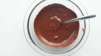 melted chocolate in a clear bowl with a spoon