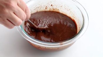 stirring a dark chocolate mixture in a bowl