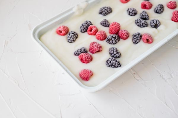 a baking tray with yogurt and assorted berries on top