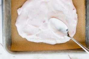 spreading yogurt onto a parchment lined tray