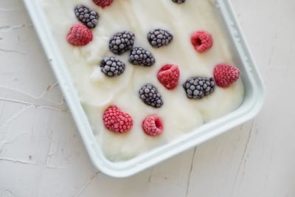 a tray of white yogurt bark topped with raspberries and blackberries