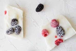 two pieces of yogurt bark topped with berries