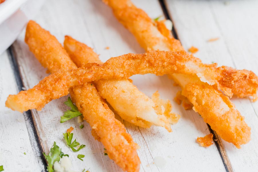 three crispy jicama fries on a white wooden table