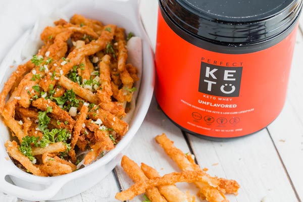 can of Perfect Keto whey protein next to a basket of jicama fries