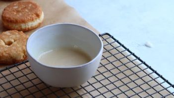 donut glaze in a small white bowl on top of a wire rack