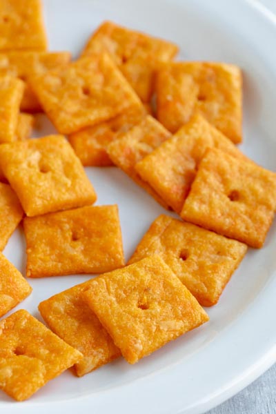 A plate with a pile of homemade cheez-its on it.