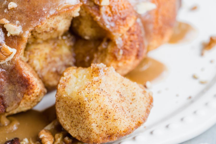 a piece of a pull-apart bread coated with cinnamon on a plate