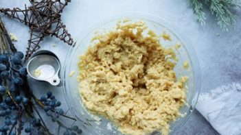 pastry dough in a clear bowl next to measure cups