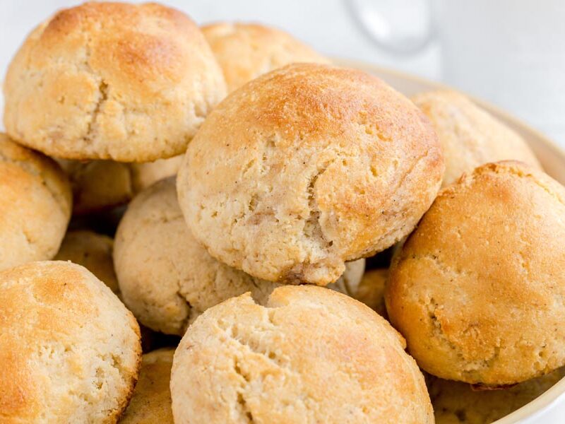 A close-up of soft, golden yeast rolls highlighting the cracked tops and fluffy texture.