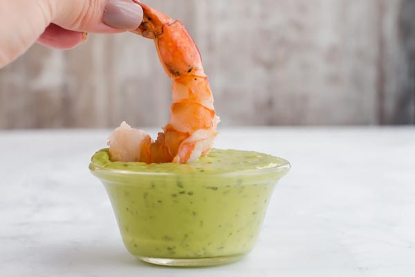 shrimp being dipped into green goddess dressing