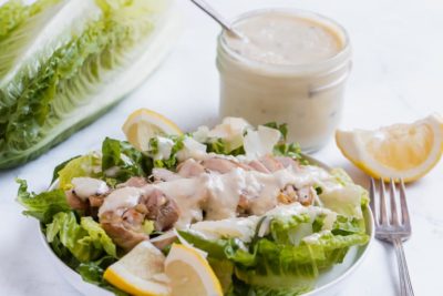 grilled chicken caesar salad with dressing on top