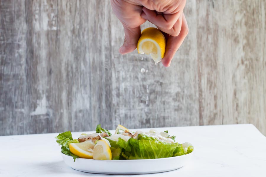 lemon squeezed on a grilled chicken caesar salad