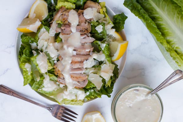 beautiful grilled chicken salad with caesar dressing on the side