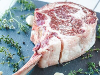 a raw tomahawk steak right after seasoning from salt