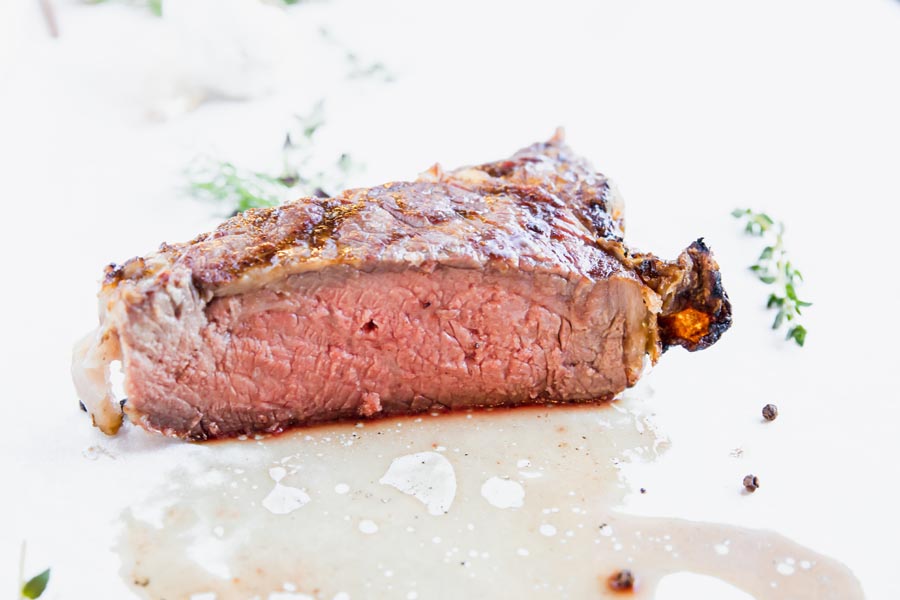 sliced ribeye steak on a white counter cooked medium rare