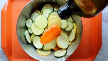 drizzling oil into sliced vegetables