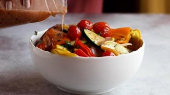 pouring dressing on grilled vegetables from a mason jar