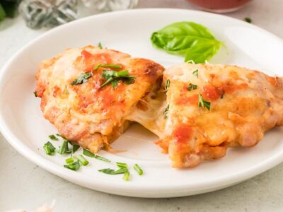 Zero carb chicken calzone cut open to reveal melted mozzarella and pepperoni inside a seasoned ground chicken crust.