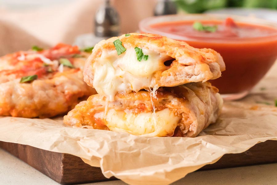Stacked zero carb chicken calzones with gooey melted cheese and pepperoni filling served with marinara sauce.