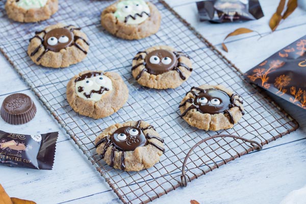 a bunch of spider and zombie cookies on a rusty metal rack