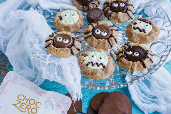 halloween cookies decorated like spiders and zombies on a plate