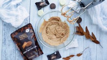 creamy peanut butter mixture in a glass bowl with choczero peanut butter bag next to it