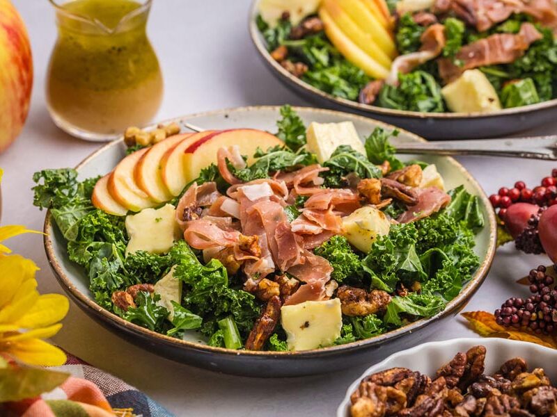 A bowl of prosciutto, brie and apple kale salad.