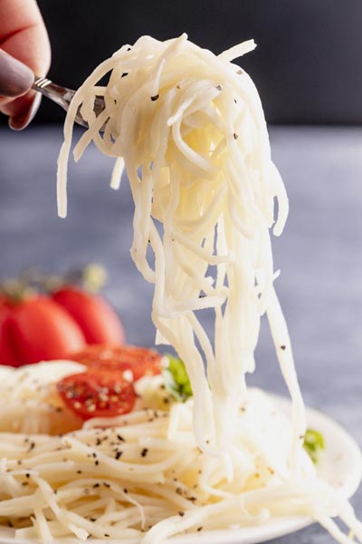 holding a fork filled with heart of palm noodles