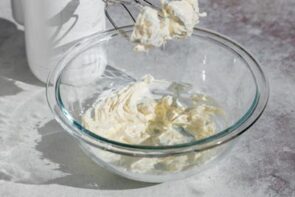 Softened cream cheese and heavy cream being mixed together until smooth for homemade cream of mushroom soup.