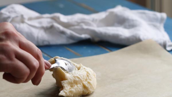 spreading homemade butter on a sheet of parchment paper