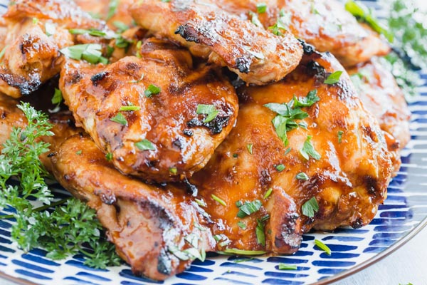 grilled marinated chicken on a blue plate sprinkled with parsley