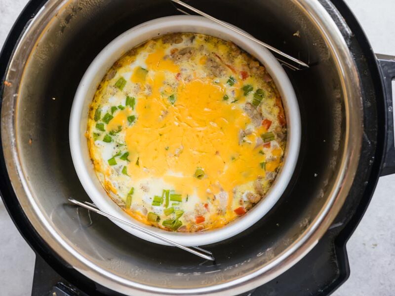 Overhead view of a cheesy breakfast casserole cooked in a round pan inside an Instant Pot.