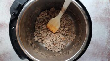 Breakfast sausage being browned and crumbled using the sauté setting of an Instant Pot.