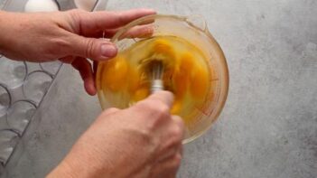 Eggs being whisked together in a measuring cup for the Instant Pot breakfast casserole.