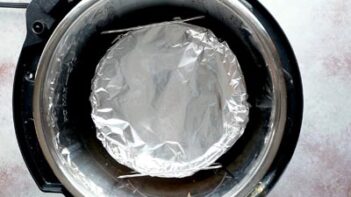 Foil-covered breakfast casserole pan placed on a trivet inside the Instant Pot for pressure cooking.