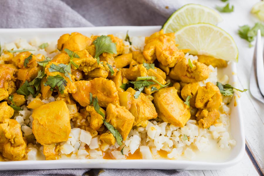 slices of lime on the corner of a plate with indian butter chicken