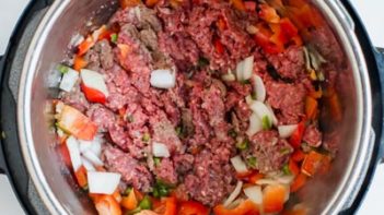 inside view of instant pot with raw ground beef and vegatables