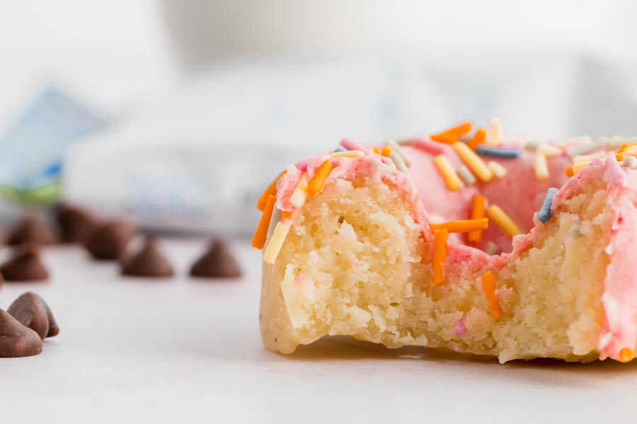 a bite out of a donut showing the fluffy texture of the donut cake inside