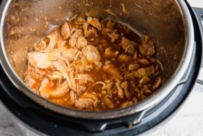 shredded sesame chicken and sauce in a pressure cooker