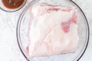 a dry slab of pork shoulder in a mixing bowl