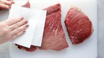 patting steak dry with a paper towel