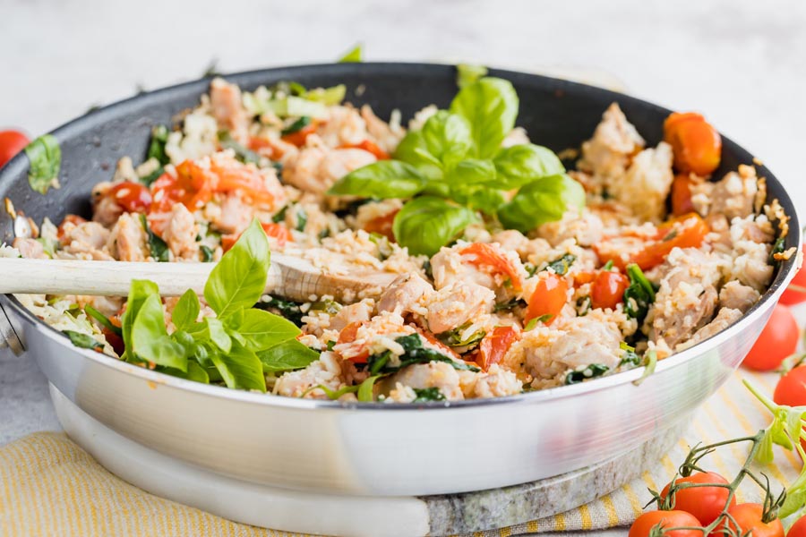 cooked chicken and rice with italian ingredients in a skillet