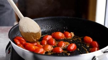 cooking tomatoes in a skillet with juices releasing