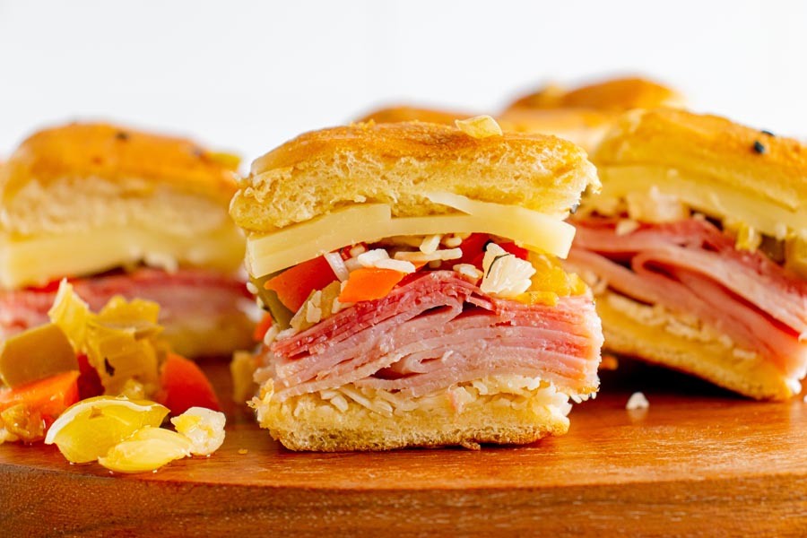Italian slider sandwiches filled with ham, salami cheese and olive mix.
