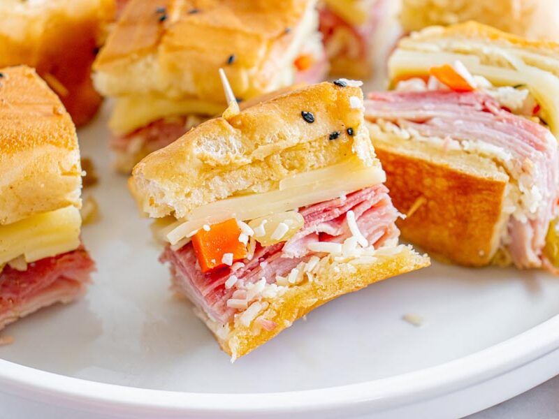 Mini sandwiches on a plate filled with cheese, meat and giardiniera mix.