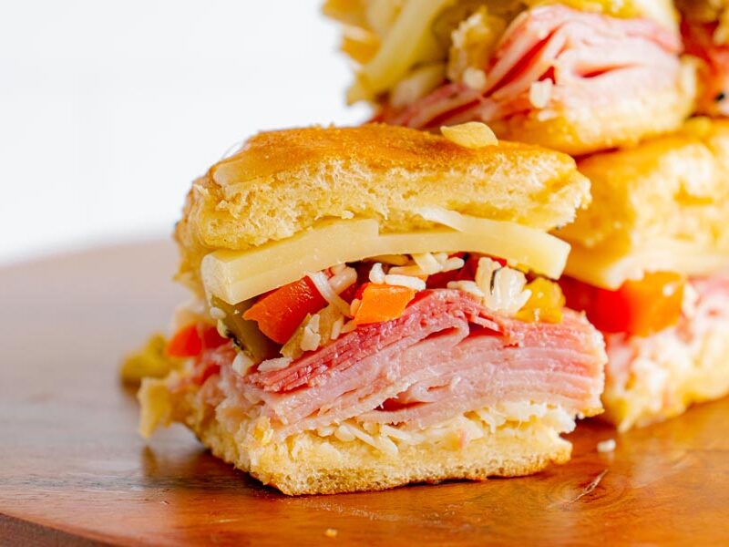 Close up of an mini low-carb Italian sandwich filled with shredded cheese, meats and olive spread.