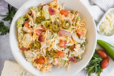 colorful lettuce based salad with jalapenos, tomatoes and cheese in a bowl