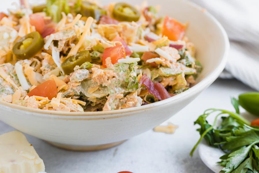 creamy romaine lettuce based salad in a white bowl