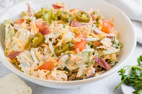 a big bowl of jalapeno salad topped with pickled jalapenos and tomatoes