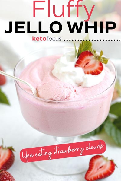 a bowl of fluffy jello whip with a spoon sitting in it and topped with a strawberry